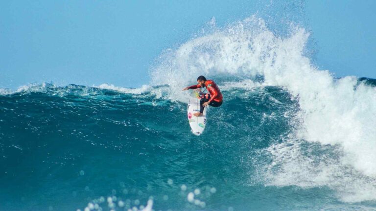 man surfing a big wave in Moorea